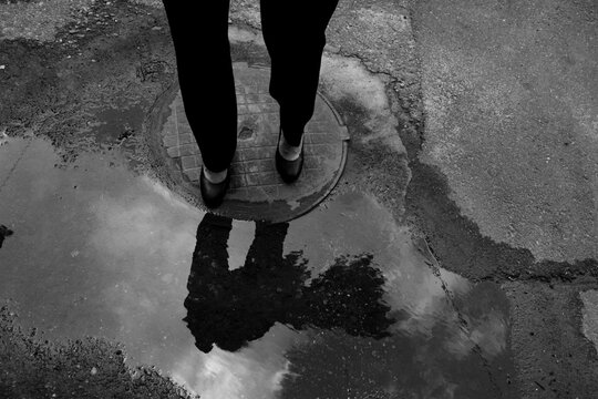 Woman&sbquo;&Auml;&ocirc;s legs reflected in street puddle