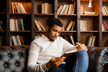 handsome young african man reading a book 