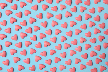 Bright heart shaped sprinkles on light blue background, flat lay