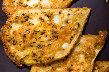 Vegetarian food - celery tuber slices fried in batter in a ceramic plate on a wooden table, close up