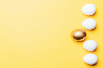 Easter eggs background. Golden, white colour egg on pastel yellow background in Happy Easter decoration. Foil minimalist egg design, modern top view template.
