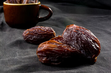 Big luxury dried date fruit on the dark surface, kurma ramadan kareem concept, close up.