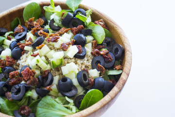Quinoa, lettuce, lambs lettuce, black olives and cucumber salad