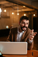 Young businessman using laptop in his office. Businessman taking a notes while working on laptop.
