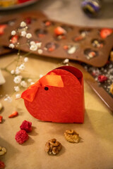 Handmade chocolate with fresh and dried fruits on light paper background in rustic style