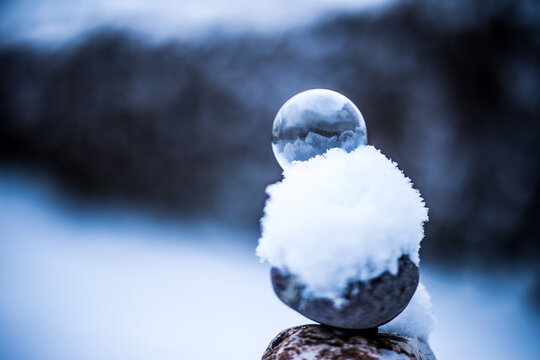 Eine gefrorene Seifenblase liegt auf dem Schnee