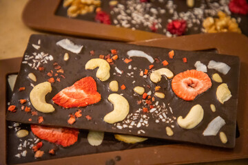 Fototapeta na wymiar Handmade chocolate with fresh and dried fruits on light paper background in rustic style