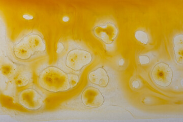 Abstract yellow paint background. Paint stains and splashes. Fluid art.