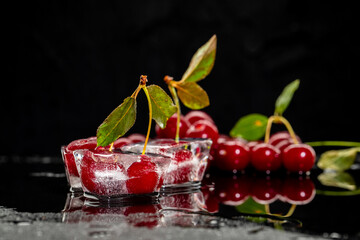 Fresh cherry berries on big ice cube on black background