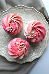 Pink cupcakes with jam, perfect cakes, pink cream cheese on plates