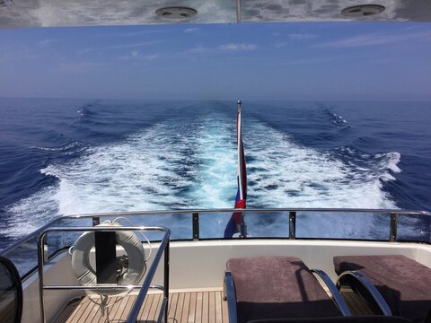 Estela en el mar dejada por los motores de un yate con hamacas en la cubierta