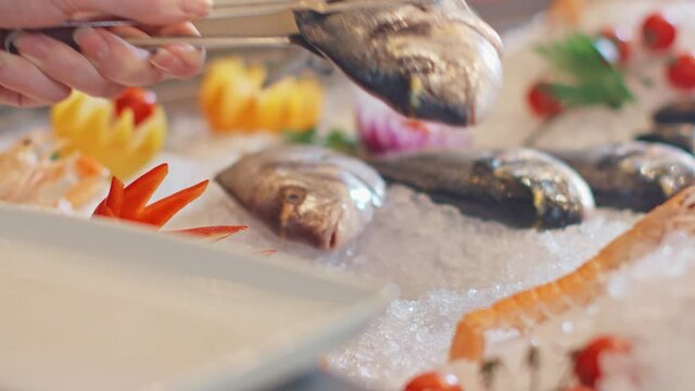 A close-up look of fresh raw sea fish on ice picked with love by chef for preparing a delicious meal.
