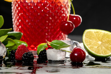 Red cocktail with berries and ice cubes