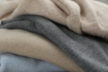 Stack of cashmere clothes as background, closeup - obrazy, fototapety, plakaty