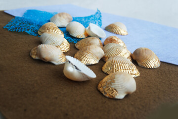 Seashells with gold leaf on a felt .  Candid.