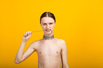 Feminine young man with metal chain. Slender body