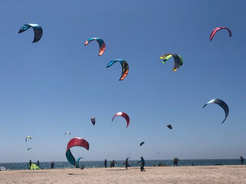 cometas de kitesurf de colores en la playa de Tarifa con el cielo azul