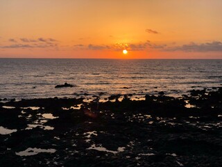 Atardecer en la playa con el cielo anaranjado y rosado