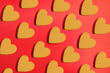 pattern of yellow hearts on a red background with bright light. creative idea with heart. love concept