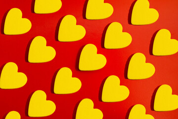 Fototapeta na wymiar pattern of yellow hearts on a red background with bright light. creative idea with heart. love concept