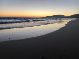 Atardecer con el cielo anaranjado y rosado en la playa cerca de la orilla del mar de Tarifa con una...