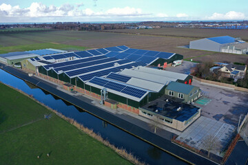 Flower bulb company with solar panels in a row on a roof. Photo taken with a drone © mauvries