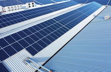 Solar panels on a roof of a company Solar panels are a cheap and sustainable way to obtain energy from sunlight. Photo taken with a drone