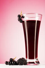 Drink from black currant on pink background