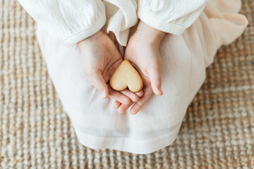 Cute young girl holding heart shaped cookie