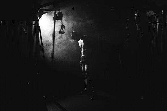  Awesome bodybuilder silhouette. Handsome power athletic man bodybuilder. Fitness muscular body on dark colour smoke background. Perfect male. tattoo, posing.