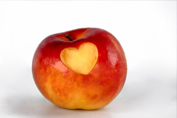 Fototapeta na wymiar Red Apple with a carved heart for Valentine's Day - expresses feelings for a person