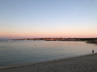 Atardecer con el cielo anaranjado y rosado en la playa cerca del mar