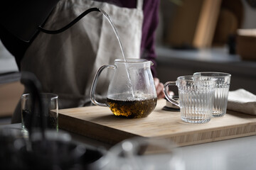 Woman is making hot tea in the kitchen.