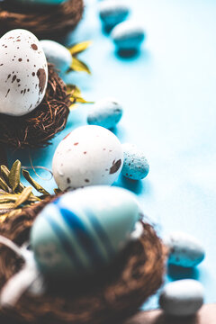 Painted Easter eggs and bird's nests decorations on a blue background
