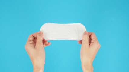 Hand is hold Hygienic daily panty liner isoalted on blue background. © nisara