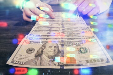 Double exposure of technology drawing hologram and us dollars bills and man hands. Data concept