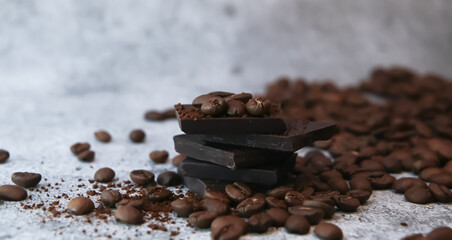 Close up of pieces of chocolate stacked over surrounded with coffee beans.