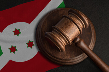 Judge gavel and flag of Burundi. Law and justice in Burundi. Violation of rights and freedoms