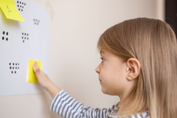 A great math activity for child - busy toddler. Little girl playing number match game.