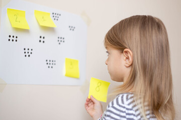 A great math activity for child - busy toddler. Little girl playing number match game.