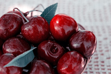 Close up of big red cherries in a basket with water drops.