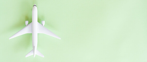 Flat lay with copy space, isolated white model aircraft on a green background. Top view with space for text.