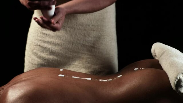 Erotic Massage lotion oil. Man massaging womans back. Spa center, body care.