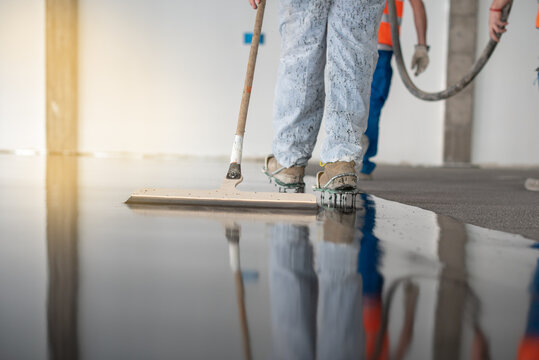 Worker working on the floor of an industrial building with special shoes to avoid damaging the floor.