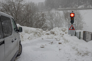 Red traffic light preventing trafiic due to snow slide or landslide in a rural place during snow...