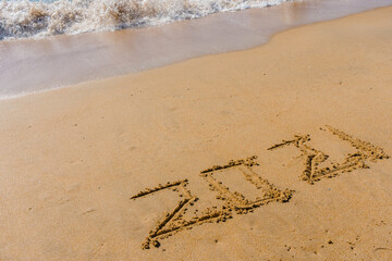 2021 year sign hand written sandy beach sunny outdoors background.