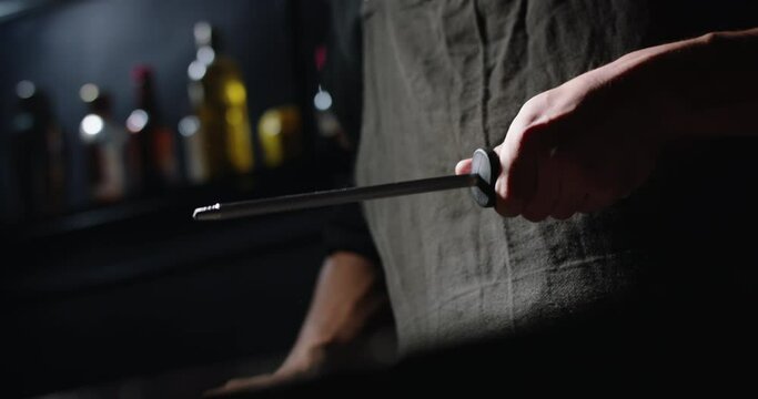 Close-up shot of chef sharpens knife for cooking, chef preparing his knife
