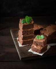 stack of square pieces of baked brown brownie pie on a wooden  board