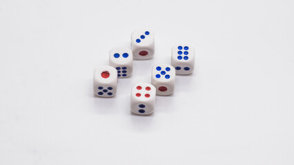 Heap of white cubic tree six dices with blue and red spikes (dots) on a white background. Game, gambling, chance and risk concept