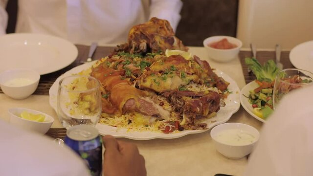 People Eating mandi rice and chicken with hands. Mandi rice served in restaurant.